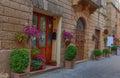 Pienza, Italy Ã¢â¬â May 27, 2017: Beautiful narrow street with sunlight and flowers in the village of Pienza, Italy Royalty Free Stock Photo